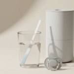 Nitrat Teststreifen im Glas Leitungswasser neben neutralem Wasserfilter und Schnuller