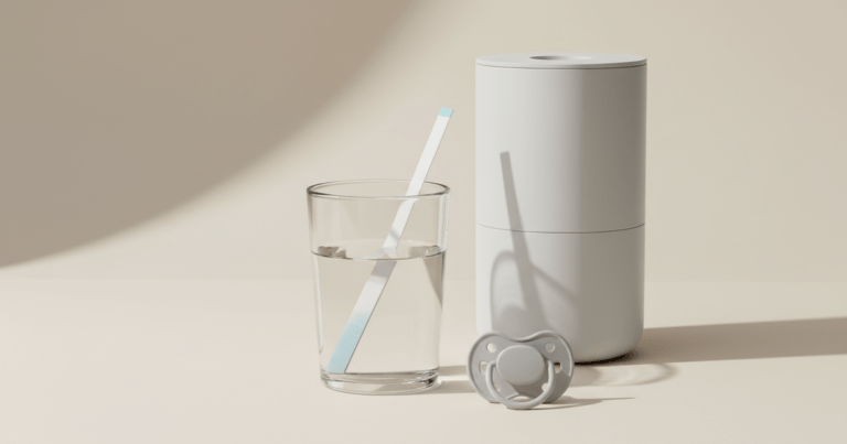 Nitrat Teststreifen im Glas Leitungswasser neben neutralem Wasserfilter und Schnuller